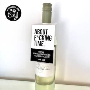 Könnte beinhalten: Eine Flasche Weißwein mit einem schwarz-weißen Etikett, auf dem "About F*cking Time." steht. Das Etikett trägt außerdem den Text "I mean... Congratulations on your engagement! Love, Allie".