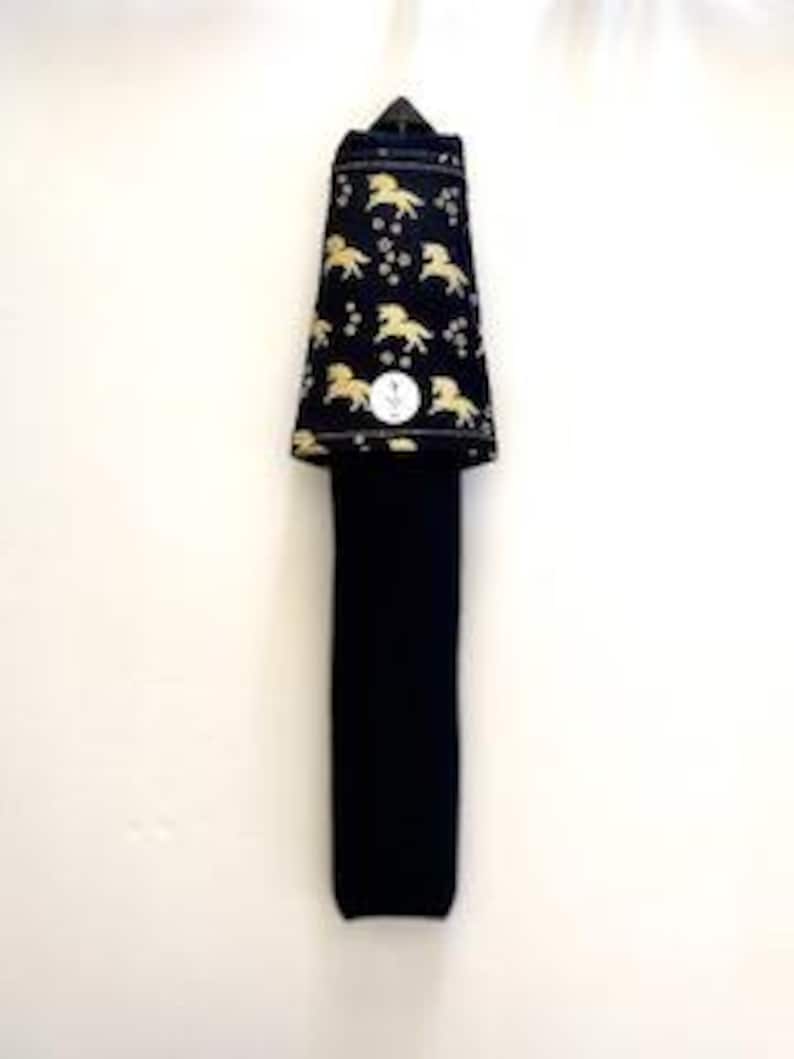 May include: A black necktie with a gold horse pattern on the top portion. The tie is folded and has a small, round white tag. The background is plain white.