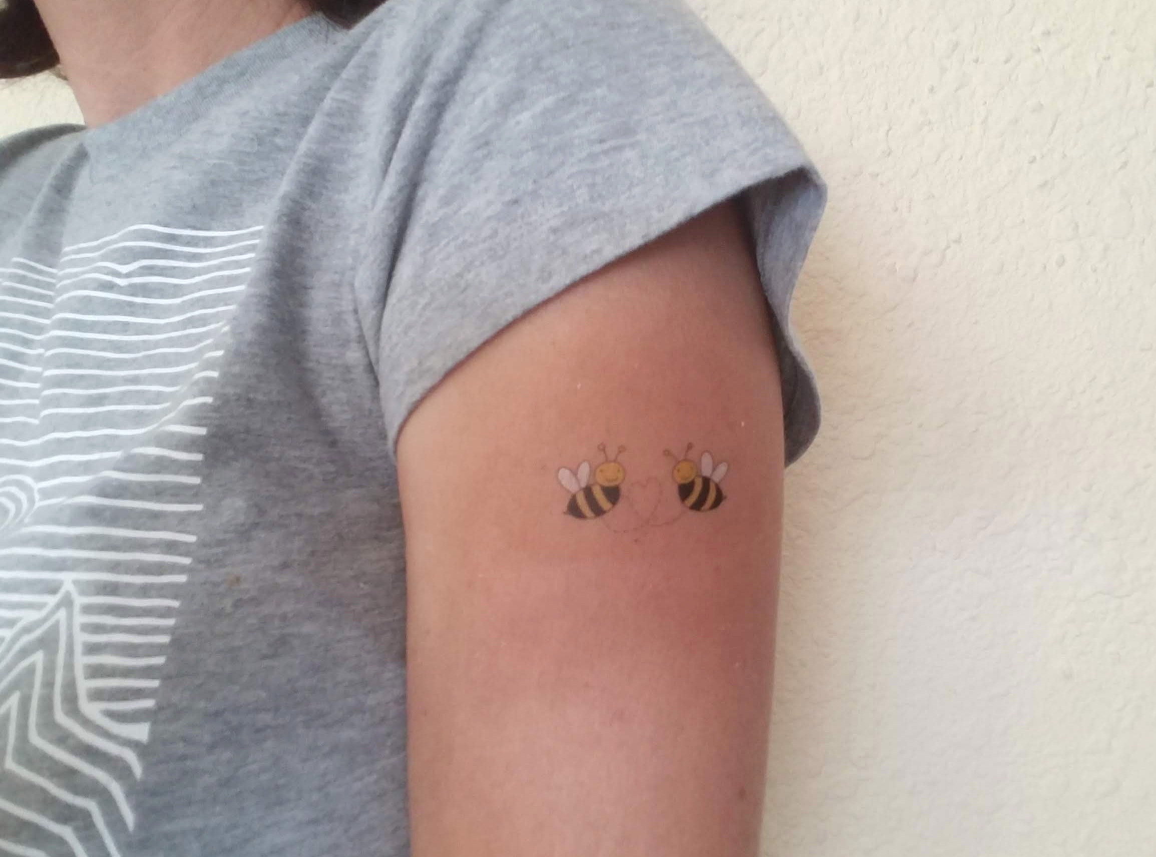 Bee tattoo on the shoulder.