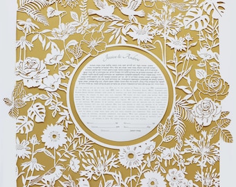 May include: A white paper cut ketubah with a gold background. The ketubah features a floral design with birds and the text "Jessica & Andrew".
