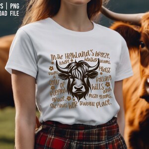 May include: White t-shirt with a brown Highland cow graphic and text. The text reads "In the Highland's breeze, where heather blooms. Midst rolling hills and misty glooms, a cow of rugged grace, she finds her tranquil place."