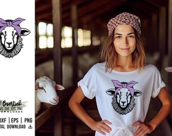 May include: A black and white illustration of a sheep wearing a purple bandana. The sheep is looking directly at the viewer. The illustration is on a white t-shirt. The t-shirt is being worn by a person in a barn.