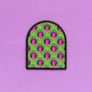 May include: A black and white arched patch with a green and pink repeating pattern. The pattern is reminiscent of the iconic shower curtain from the film "Psycho".