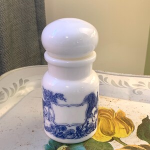 Peut inclure: Pot en céramique blanche avec un motif floral bleu et blanc. Le pot a un couvercle rond et une étiquette vierge.