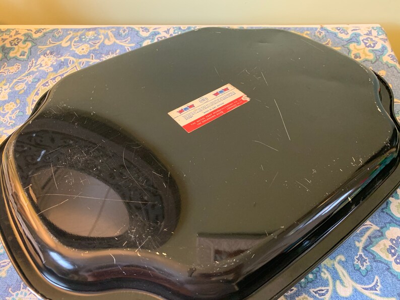Pu&ograve; includere: Teglia da forno in metallo nero con bordo ondulato. La teglia ha un adesivo sul fondo che recita "New York Metal Ware Corp.  Made in USA".