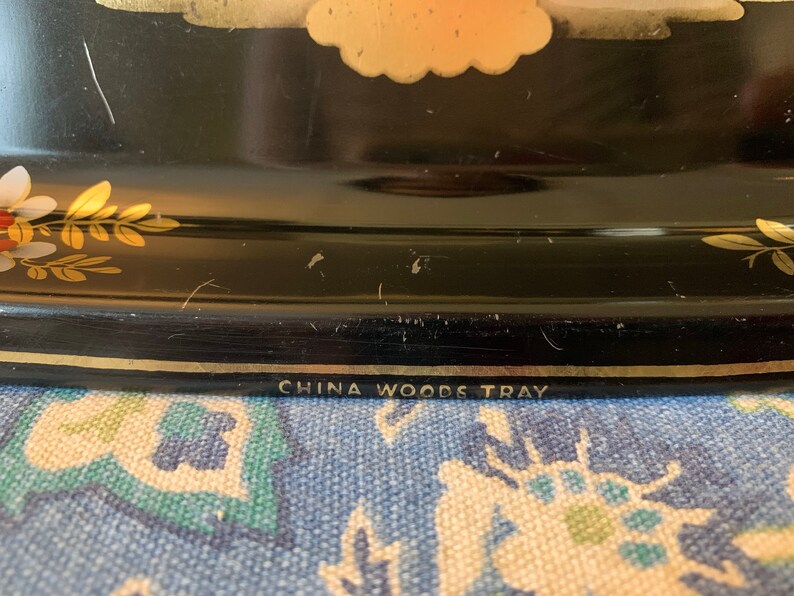 Pu&ograve; includere: Vassoio nero con bordo dorato e motivo floreale. Sul fondo del vassoio &egrave; stampato "China Woods Tray".