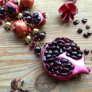 ガーネットとザクロのチャームがチェーンについたネックレス。ペルセポネの女神のシンボル。1月の誕生石。