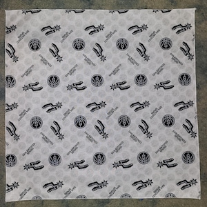 Puede incluir: Bandana blanca con un patrón repetido de balones de baloncesto negros, estrellas y las palabras "San Antonio Spurs" y "Spurs Dinindiny NVS".
