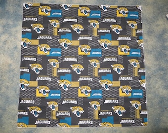 May include: Black fabric with a repeating pattern of gold and blue Jacksonville Jaguars logos. The logos feature a jaguar head with the words "Jacksonville Jaguars" written below.