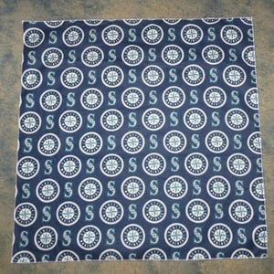 Può includere: Un bandana di stoffa blu con un motivo ripetuto di cerchi bianchi che contengono una bussola e la lettera "S" per Seattle Mariners.
