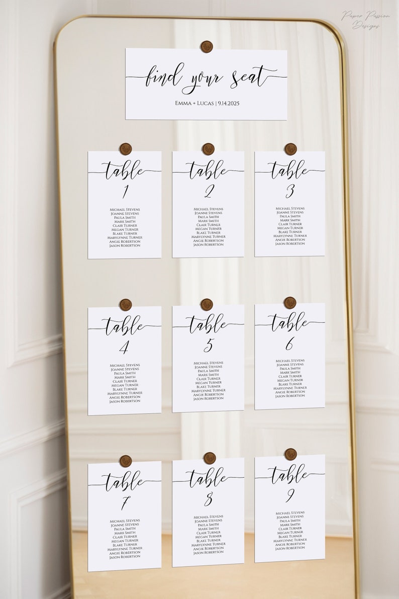 wedding seating chart cards placed with wax seals on a modern gold frame mirror.  9 table cards are displayed with table numbers and guest names. find your seat card with bride and groom names and wedding date displayed above the table cards.