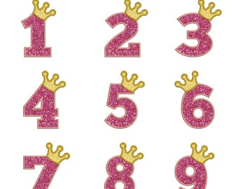 May include: Pink glitter numbers 1 through 9 with gold crowns on top.
