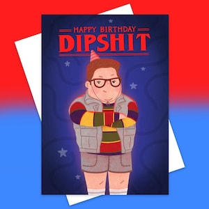 May include: Greeting card with a cartoon illustration of a person wearing glasses, a party hat, and a gray vest. The card reads "HAPPY BIRTHDAY DIPSHIT" in red letters against a blue background with stars. A white envelope is visible.