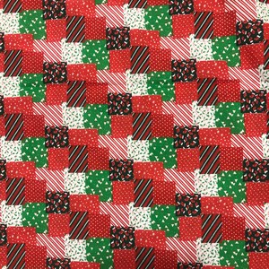 May include: A patchwork fabric with a repeating pattern of red, green, and black squares. The squares feature various designs, including stripes, polka dots, and Christmas tree motifs. The fabric is suitable for holiday-themed crafts and sewing projects.