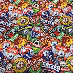 Puede incluir: Una colorida tela con temática de fútbol con un patrón repetido de balones de fútbol, jugadores y texto. El diseño incluye varias insignias y logotipos en rojo, azul, verde y amarillo. Las palabras "Soccer", "Football" y "Tournament" son visibles.
