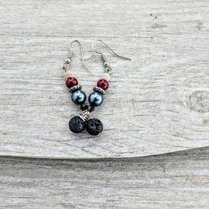 May include: A pair of silver earrings with black lava rock beads and blue and red glass beads.