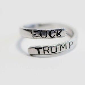 May include: A silver ring with the words "FUCK TRUMP" engraved on it.