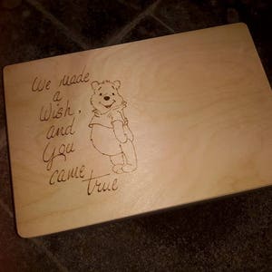 Peut inclure: Une planche à découper en bois avec un personnage de Winnie l'ourson et le texte "We made a wish, and you came true".