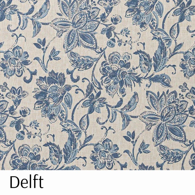 Puede incluir: Una tela con un patr&oacute;n floral repetitivo en tonos azules y blancos. El dise&ntilde;o presenta grandes flores y hojas estilizadas sobre un fondo neutro. La palabra "Delft" est&aacute; impresa en la parte inferior de la imagen.