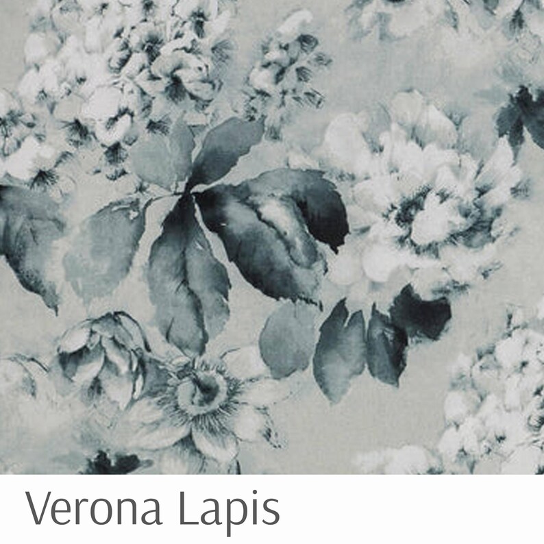 Puede incluir: Un dise&ntilde;o floral en tonos grises y azules, con grandes flores y hojas. El patr&oacute;n tiene un efecto acuarela, con bordes suaves y un aspecto texturizado. El texto "Verona Lapis" est&aacute; en la parte inferior.