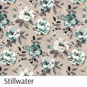 Puede incluir: Tela floral con un patr&oacute;n repetido de grandes flores estilizadas en tonos turquesa, blanco y gris sobre un fondo beige. La tela tiene una calidad pict&oacute;rica, con pinceladas visibles. La palabra "Stillwater" est&aacute; impresa en la parte inferior.