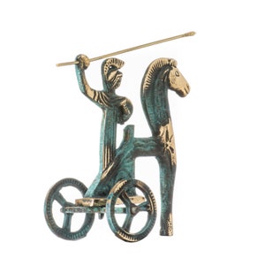 May include: A bronze-toned sculpture of a warrior in a chariot pulled by a horse. The warrior holds a spear, and the chariot has two wheels. The sculpture has a verdigris finish, with gold accents on the horse and chariot.