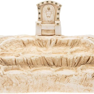 Puede incluir: Un trono de cerámica blanca con una corona dorada se asienta sobre una base de color arena con dos juegos de escaleras que conducen a él.