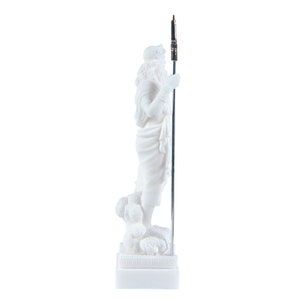 May include: White marble statue of a Greek god holding a spear, standing on a base with a Greek key design.