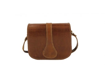 May include: A brown leather crossbody bag with a flap closure and a single strap. The bag has a simple design and is made of high-quality leather.