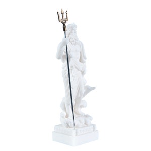 May include: White marble statue of Poseidon, the Greek god of the sea, holding a trident. The statue is standing on a square base with Greek lettering.