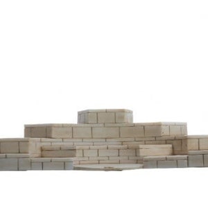 Op de afbeelding: Een meerlaags display gemaakt van gestapelde rechthoekige blokken, elk met een baksteenpatroon. Het display is gemaakt van een lichtbeige materiaal en is in een piramidevorm gerangschikt.