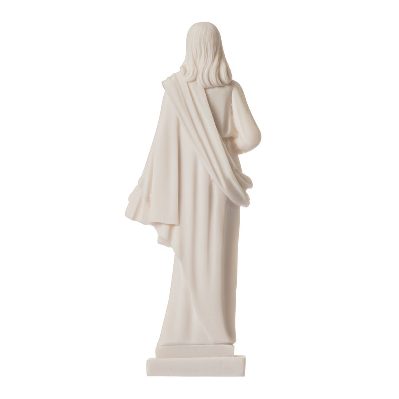 May include: White marble statue of a person wearing a long robe, standing on a square base. The statue is facing away from the camera.
