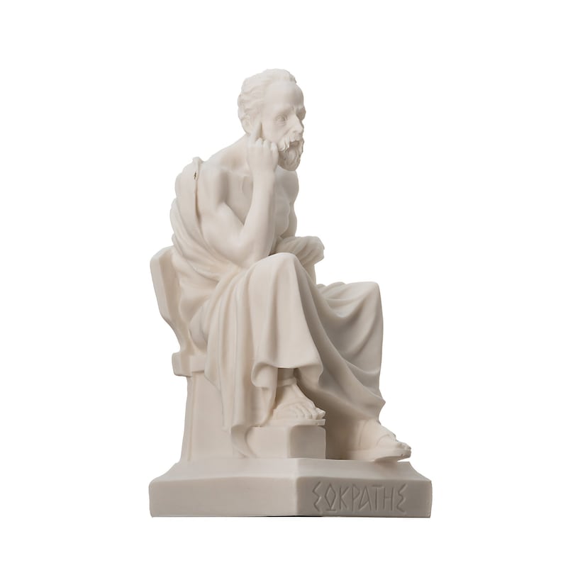 May include: White marble statue of the Greek philosopher Socrates sitting on a stone bench. The statue is detailed and shows Socrates in a thoughtful pose with his hand on his chin. The base of the statue is inscribed with the word "&Sigma;&Omega;&Kappa;&Rho;&Alpha;&Tau;&Eta;&Sigma;" in Greek.