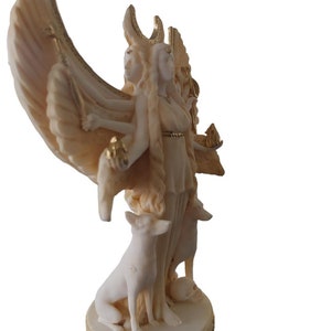 May include: White marble statue of a triple goddess with wings, holding a staff and a crescent moon. The goddess is standing on a base with two dogs at her feet.