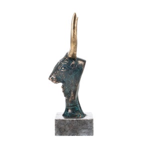 May include: Bronze sculpture of a bull's head with gold horns on a gray stone base.