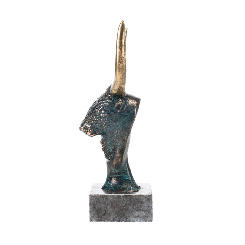 May include: Bronze sculpture of a bull's head with gold horns on a gray stone base.