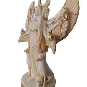 May include: A white and gold statue of a three-headed goddess with wings, holding a snake, a torch, and a crescent moon. The goddess is standing on a base with two dogs and a skull.