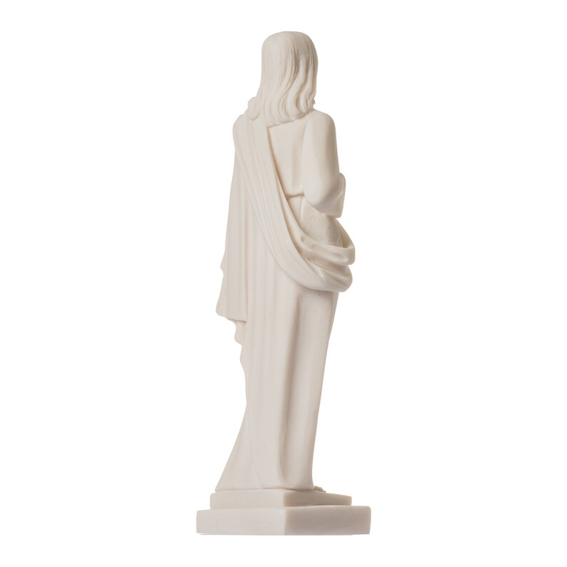 May include: White marble statue of a person wearing a robe, standing on a white base. The statue is facing away from the viewer.