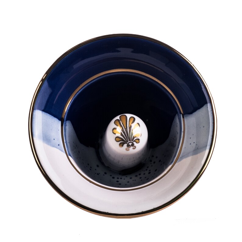 May include: A blue and white ceramic ring holder with a gold rim and a gold floral design. The holder is empty and ready to display a ring.