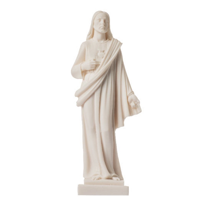May include: White marble statue of Jesus Christ with a heart in his hand, wearing a robe and standing on a base.