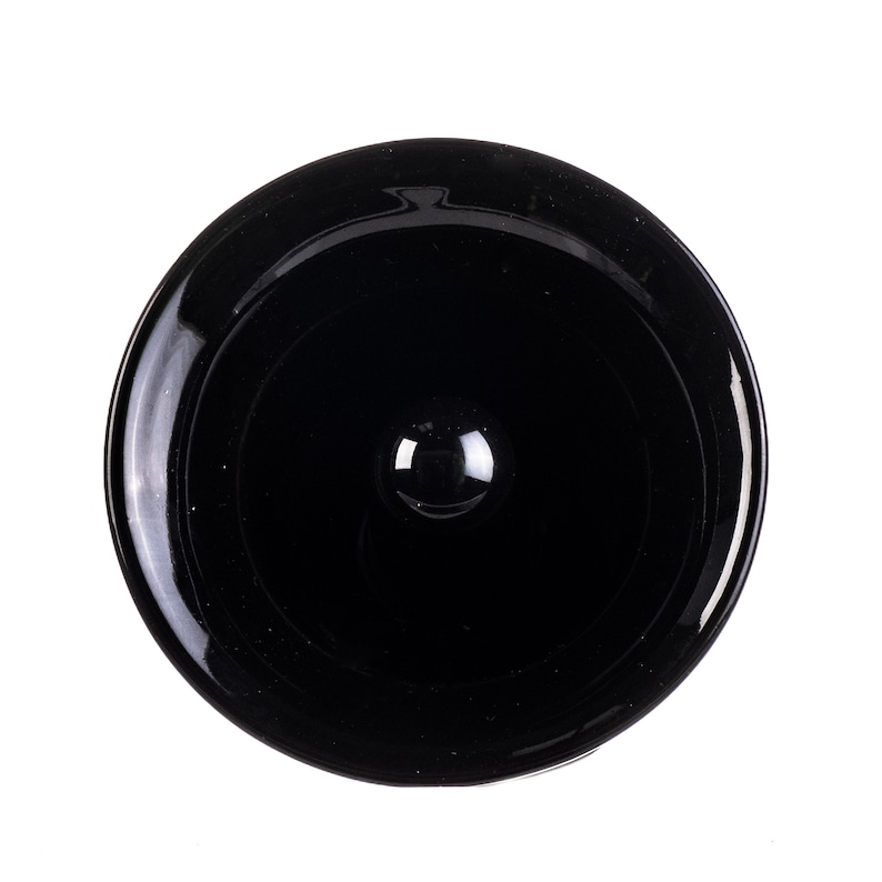 May include: A black glass bottle stopper with a smooth, rounded top.