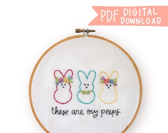 Op de afbeelding: Borduurkunst in een hoepel met drie pastelkleurige Peeps met bloemenkransen en de tekst "these are my peeps".