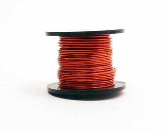 Puede incluir: Una bobina de alambre de cobre rojo en un carrete de plástico negro.