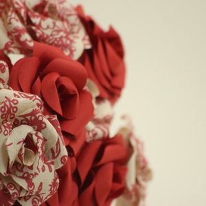 A dozen handmade flowers. This high quality, paper rose bouquet will last forever, made with mixed red and patterned paper.