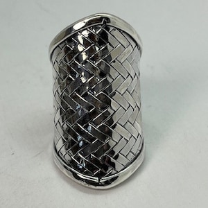 May include: A silver ring with a woven design. The ring is wide and has a rounded shape.