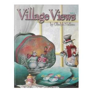 May include: Book cover for "Village Views" book 6 by Gladys Neilson. The cover features a painted winter scene with snowmen and a village in the background.