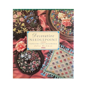 May include: A book titled "Decorative Needlepoint: Tapestry and Beadwork" by Julia Hickman. The cover features a variety of needlepoint projects, including a floral design, a geometric pattern, and a design with leaves.