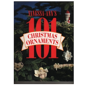 Op de afbeelding: Boekomslag met de titel "Vanessa-Ann's 101 Christmas Ornaments" in rode tekst op een donkergroene achtergrond met een kerstboom en kerstversiering.