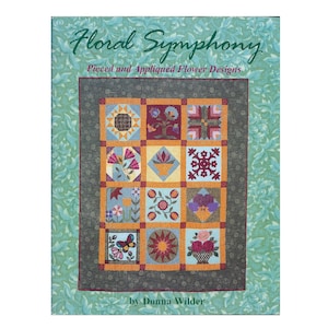 May include: A book titled "Floral Symphony: Pieced and Appliqued Flower Designs" by Donna Wilder. The cover features a quilt with a variety of colorful flower designs in a grid pattern.