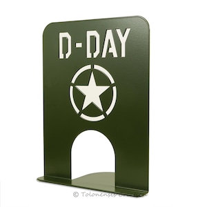 Może przedstawiać: Zielony metalowy podpórka na książki z białym wzorem gwiazdy i koła oraz tekstem "D-DAY".